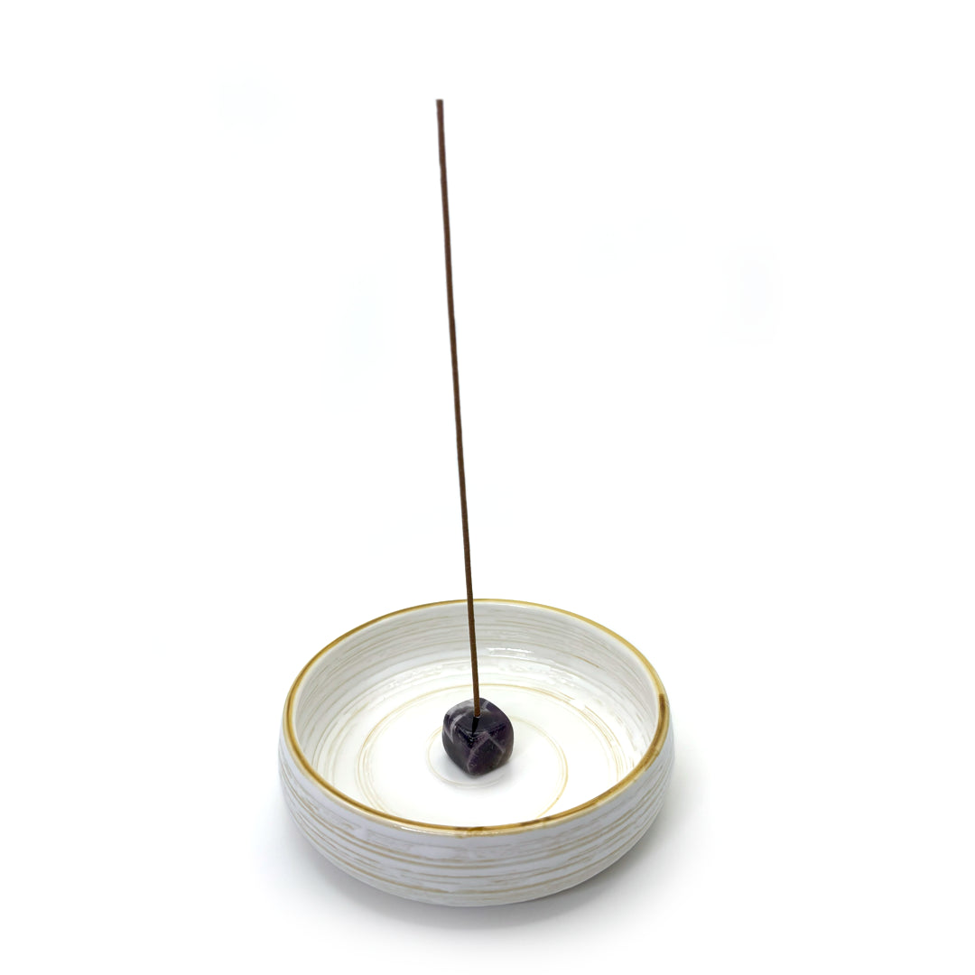 Amethyst incense holder placed on white ceramic incense dish
