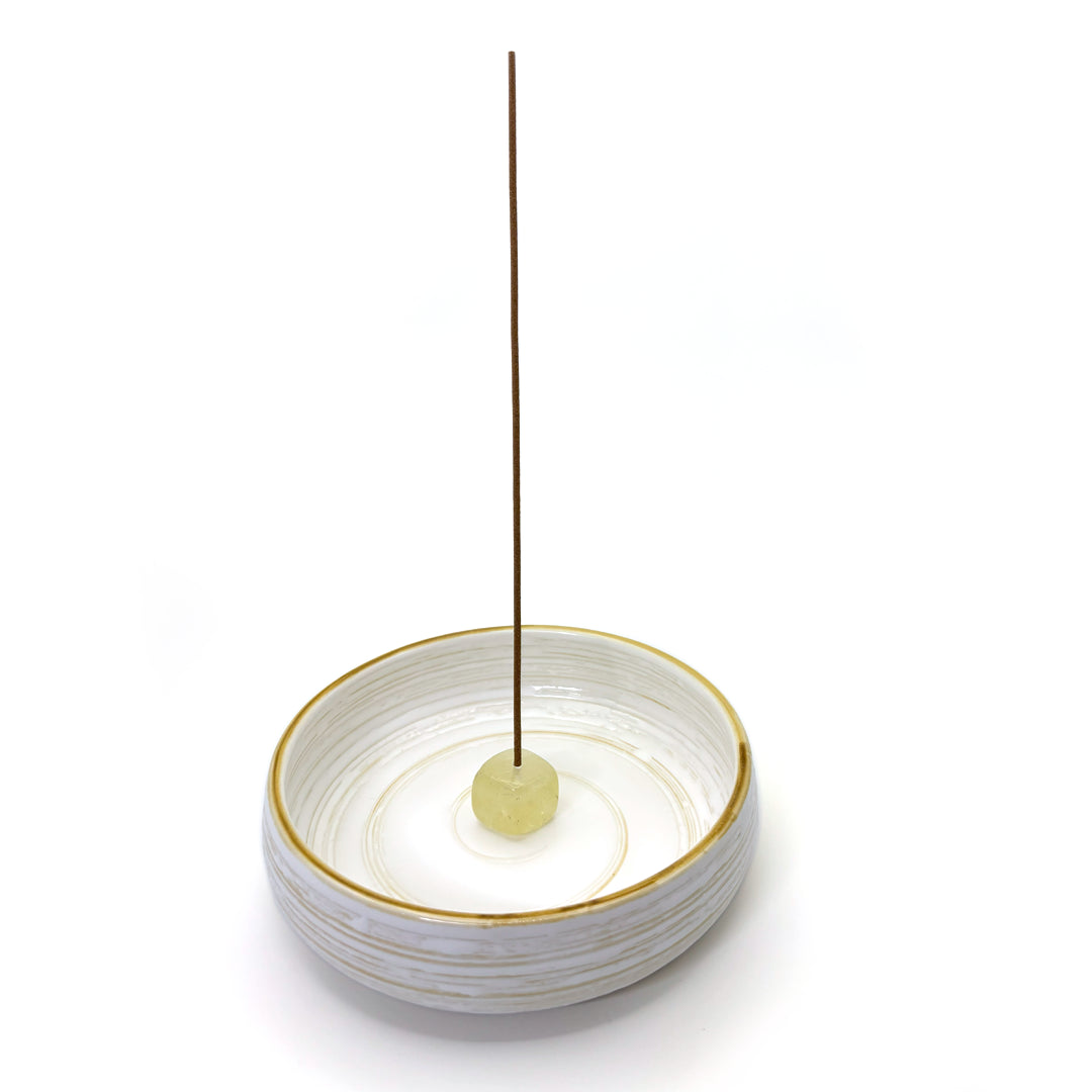 Citrine crystal incense holder placed on ceramic incense dish