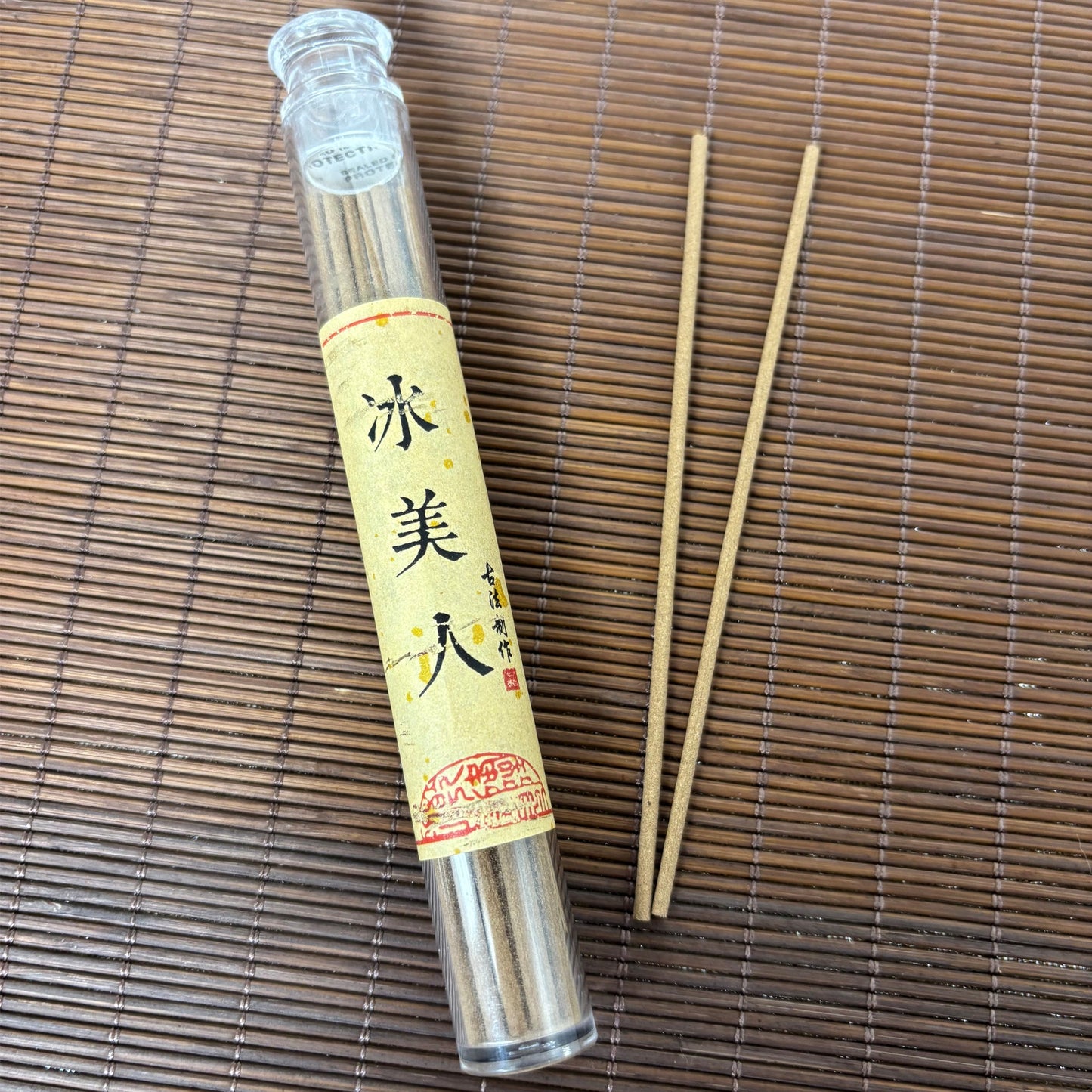 Frozen Beauty incense with soft floral sticks in clear plastic tube on bamboo mat