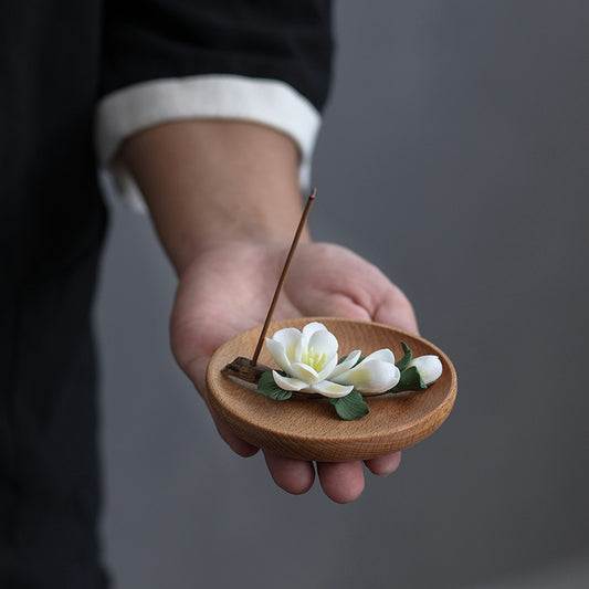 Hand holding a handmade ceramic magnolia incense holder – mindful living decor