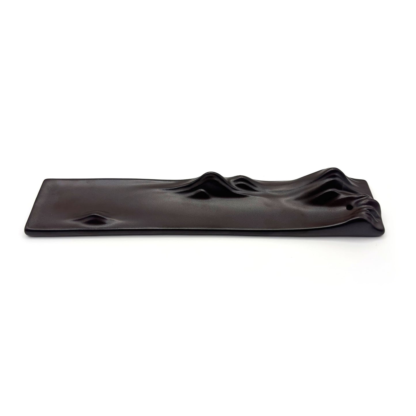 Flat top view of minimal black ceramic incense holder with landscape ridge details