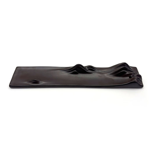 Flat top view of minimal black ceramic incense holder with landscape ridge details