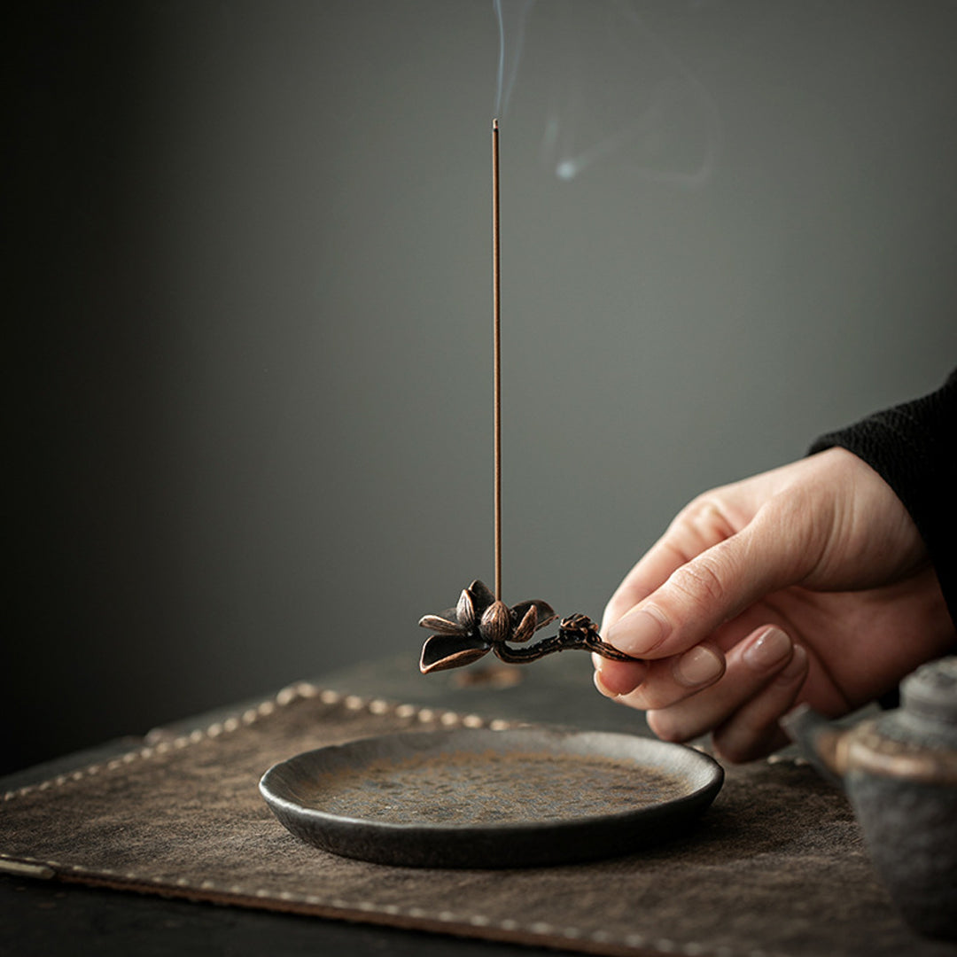 Hand holding gilded ceramic incense base with metal lotus holder – Lamtong