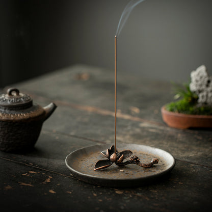 Burning incense on gilded lotus ceramic holder during tea ritual – Lamtong