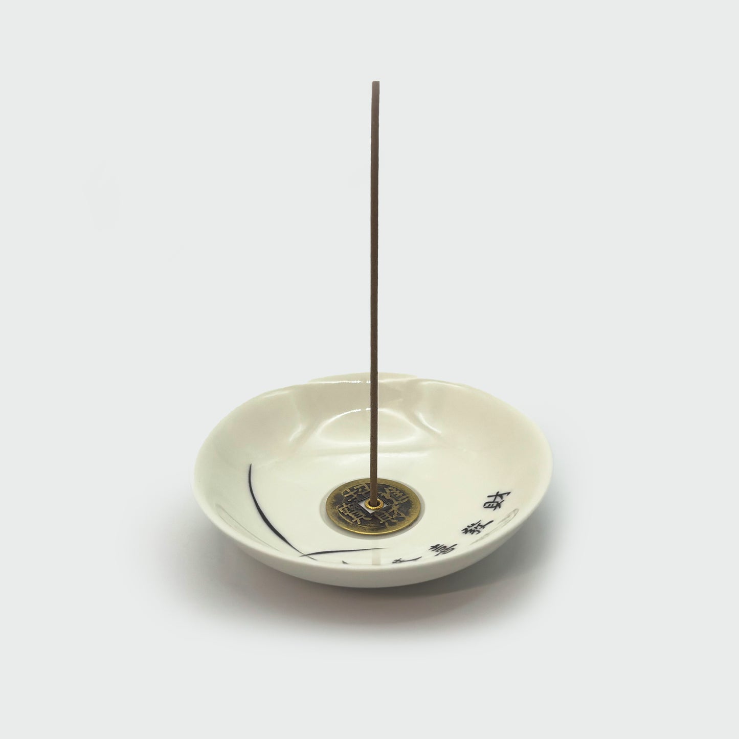 Ceramic incense holder in use with inserted incense stick