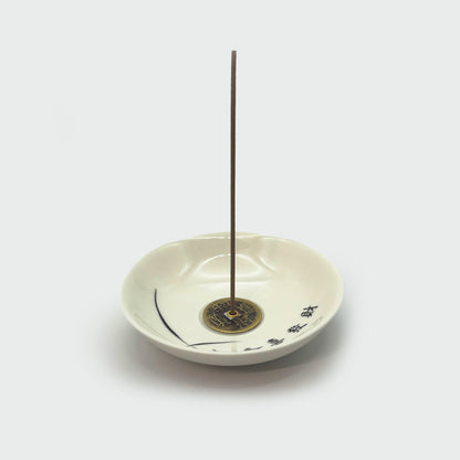 Ceramic incense holder in use with inserted incense stick