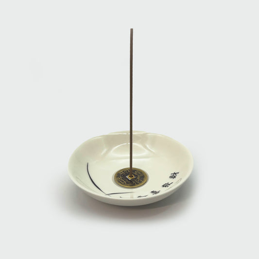 Ceramic incense holder in use with inserted incense stick