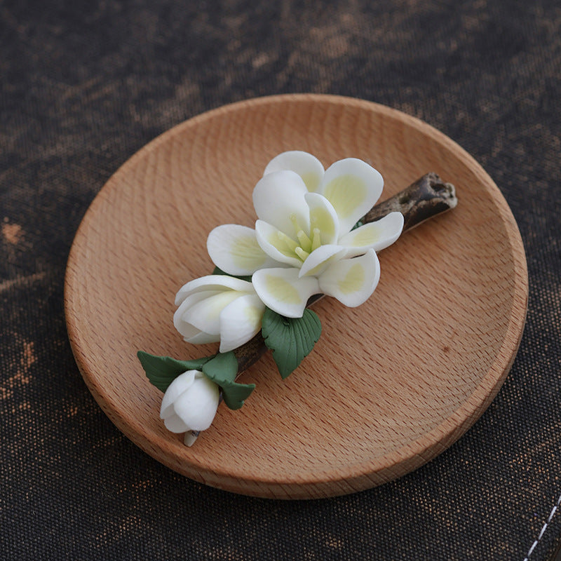 Close-up of handmade ceramic magnolia on incense holder base