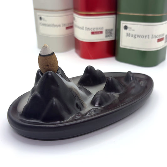 Mugwort backflow incense cone on ceramic mountain burner
